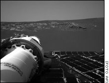 Paisaje marciano
capturado por las cámaras del Opportunity, parte del cual se ve en el ángulo inferior izquierdo de la fotografía.