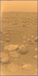 Esta imagen fue enviada el 14 de enero de 2005 por la sonda Huygens durante su exitoso descenso en Titán. Es la imagen coloreada, resultado de haber añadido datos espectrales de reflexión, y da una mejor indicación del color real de la superficie (Foto:ESA/NASA/Univ.de Arizona). Los objetos en forma de roca en la mitad de la imagen tienen cerca de 15 y 4 centímetros respectivamente y están a una distancia de 85 cemntímetros.